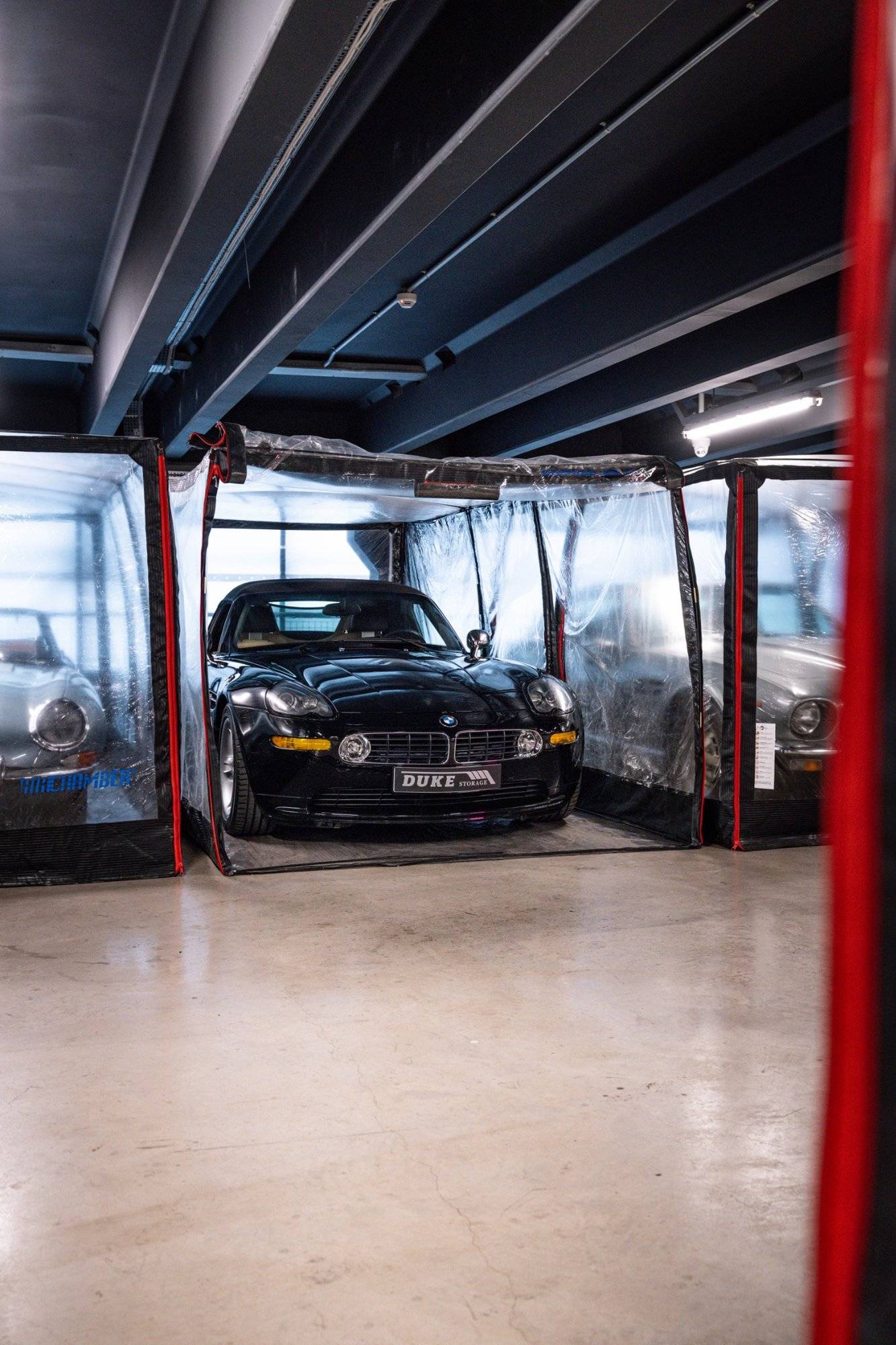 Black sports car inside a clear climate-controlled bubble in a 1950s industrial venue from Love Locations.