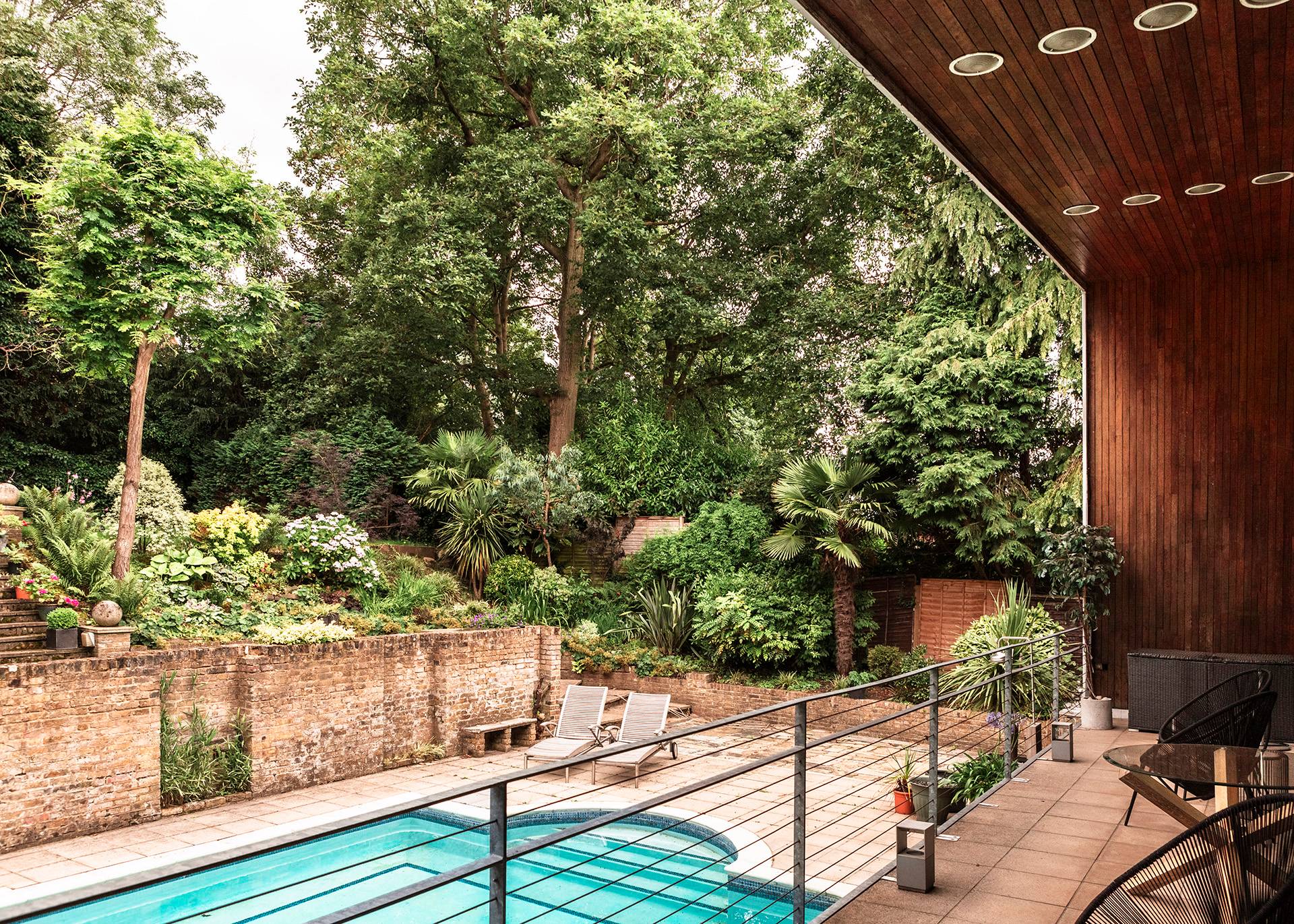 Stunning view from the upper deck looking down across a private outdoor swimming pool and landscaped terraced gardens, Love Locations BR1.