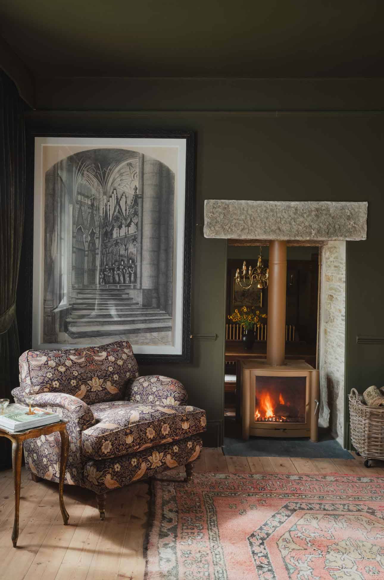 Cozy fireplace nook in a green-painted sitting room shoot space in a historic Cornish manor available from Love Locations.