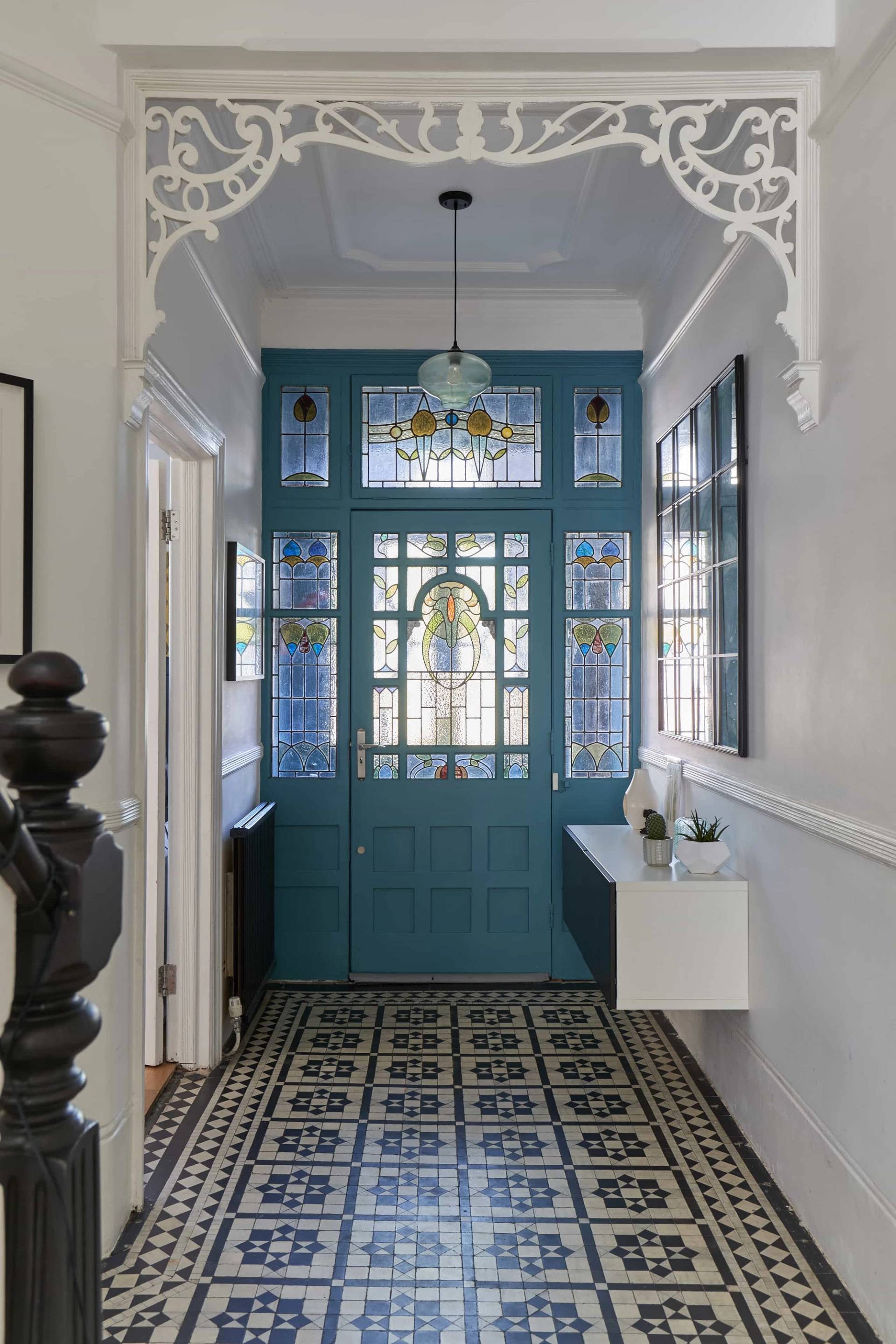 Victorian front hallway featuring stained glass front door panels in bright blue and yellow, with tiled flooring, Love Locations W3.