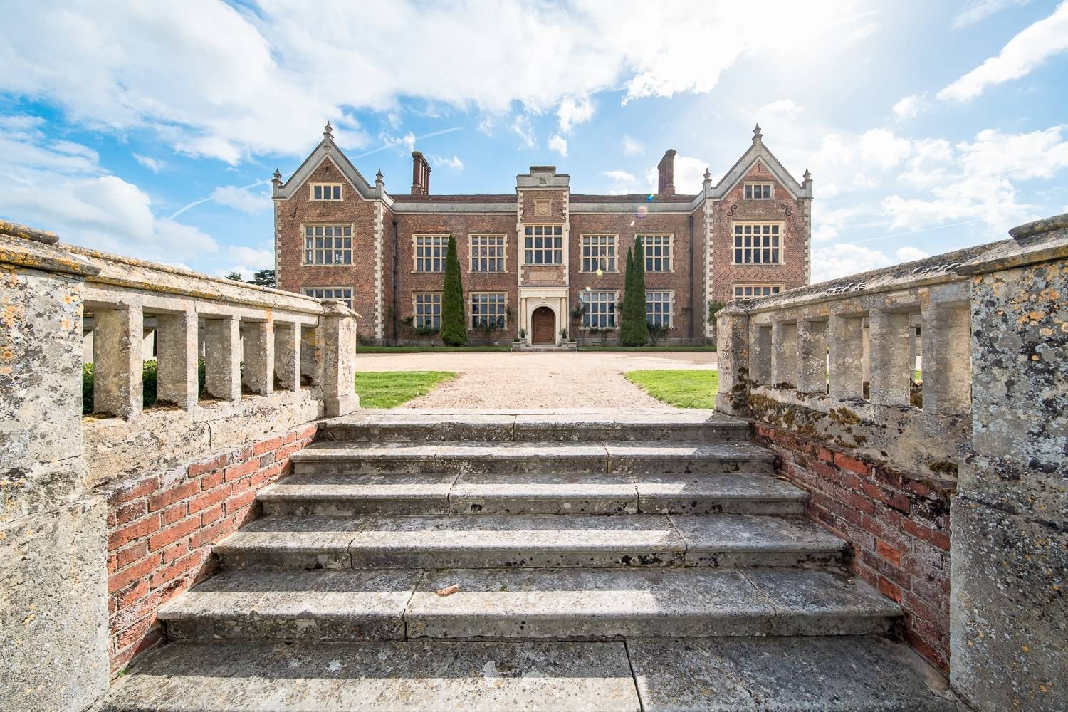 Grand brick Elizabethan manor house facade and stone entrance steps at North Mymms Park in Hertfordshire AL9 from Love Locations.