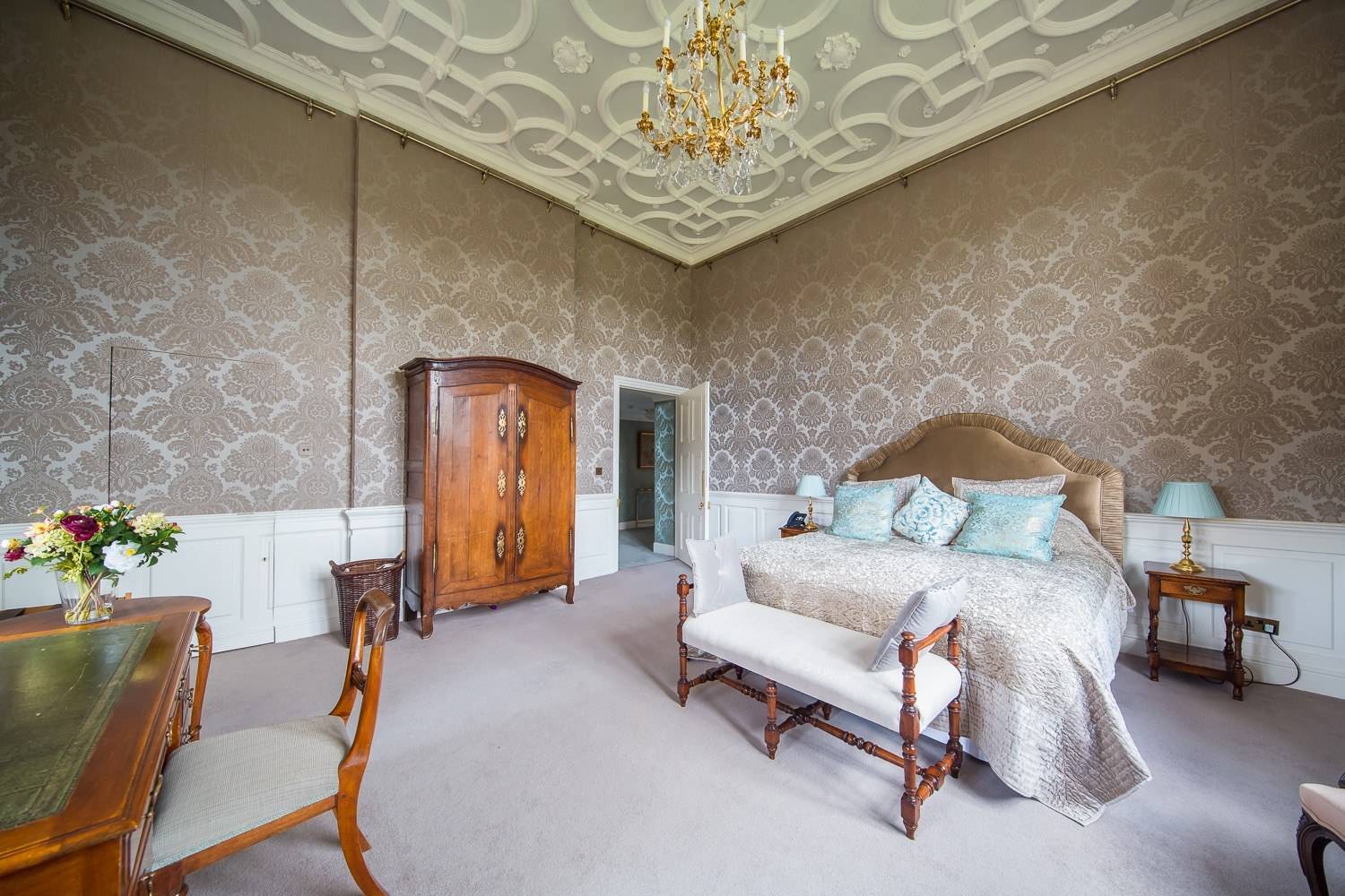 Classic country house bedroom shoot space with damask wallpaper, ornate plaster ceiling, and neutral decor from Love Locations.