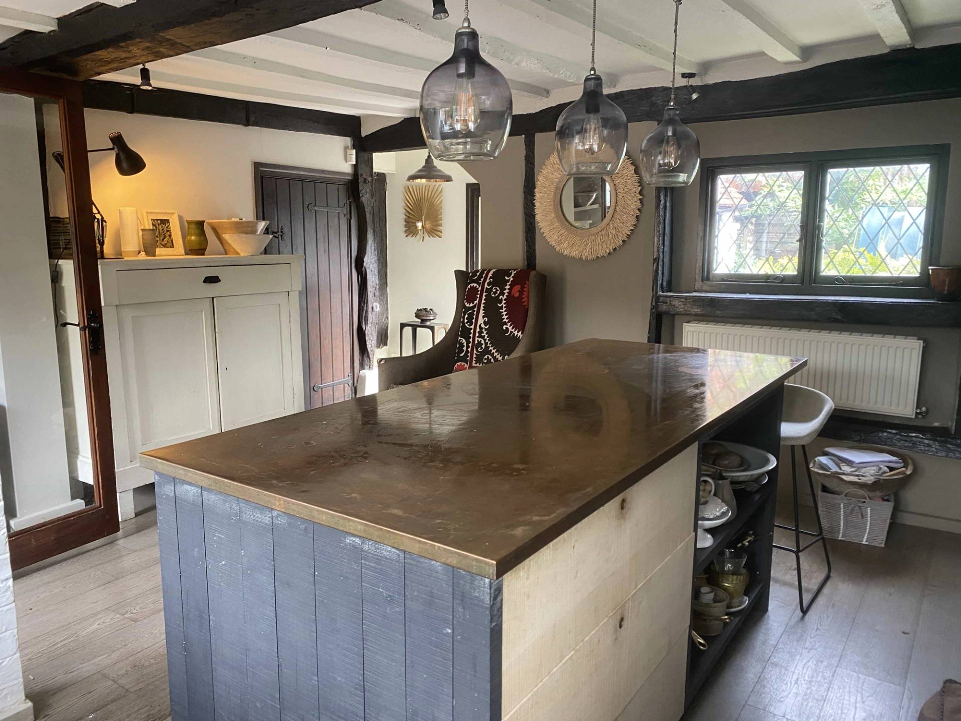 Historic Tudor cottage kitchen location in a woodland valley in RG9 6QD featuring exposed black timber beams, a rustic island counter, and period charm, ideal for food media and commercial cooking shows via Love Locations.