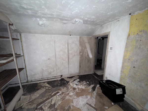 Atmospheric derelict room covered in plaster dust, featuring discarded trunks and vintage suitcases for set dressing, Love Locations Nottingham.