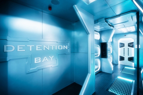 Spaceship hallway leading towards a glowing 'Detention Bay' sign, unique sci-fi studio space on Albert Embankment by Love Locations.