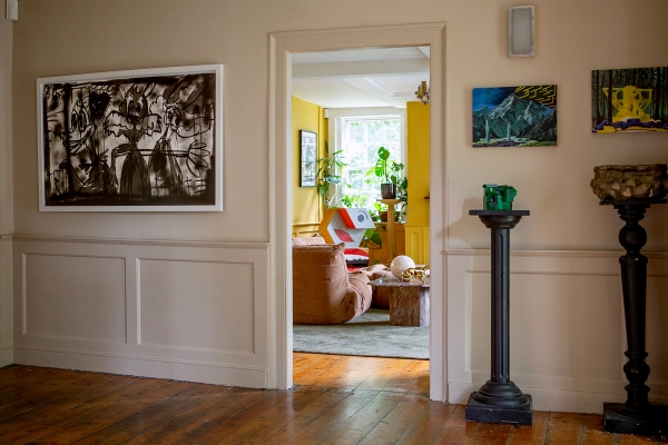 Open doorway transition looking from a neutral hallway into a bright yellow panelled lounge room, Love Locations ME13.