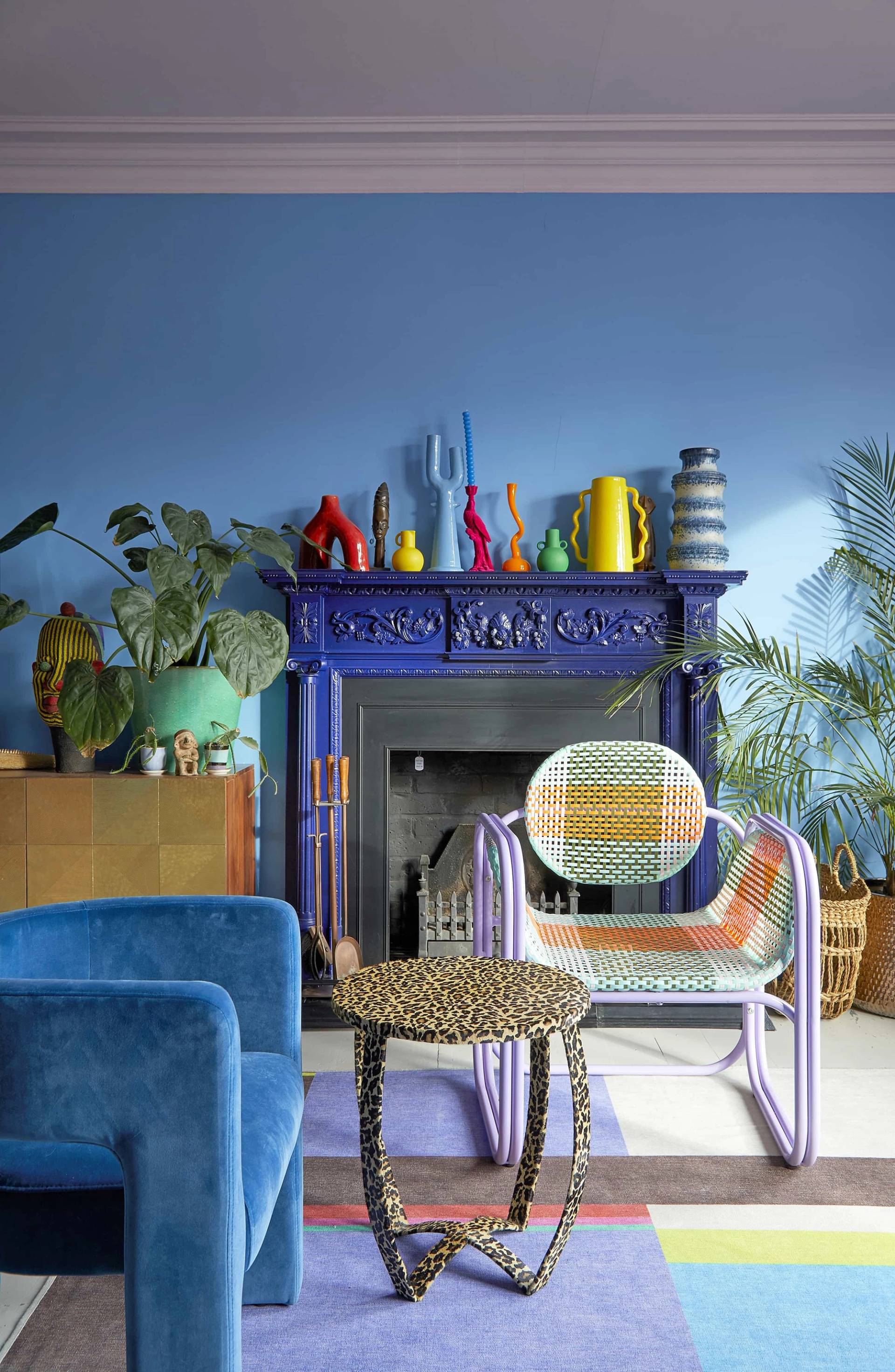 Ornate dark blue fireplace surround styled with a collection of colorful ceramic vases and yellow accent decor, Love Locations SE6.