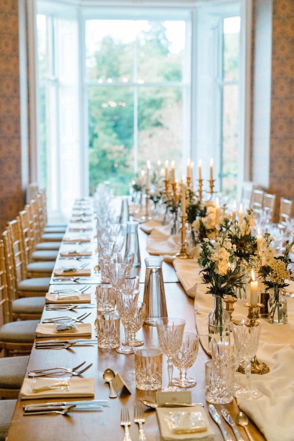 Long banqueting dining table set for an event with gold chairs and floral centerpieces in Fife, Love Locations KY15.