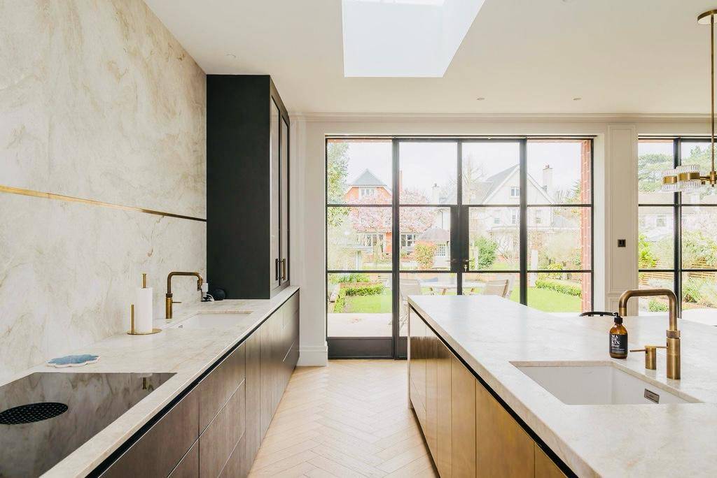 Sunlit modern kitchen looking out through black metal Crittall glass patio doors, Love Locations TW11.