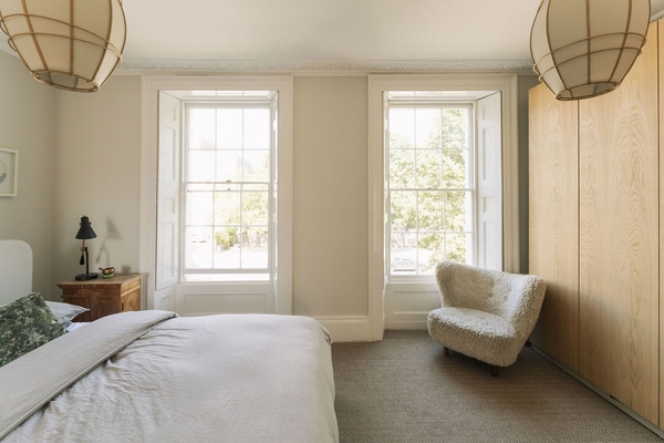Bright bedroom interior showing dual sash windows and a modern armchair, perfect for lifestyle editorial photography, Love Locations SW9.