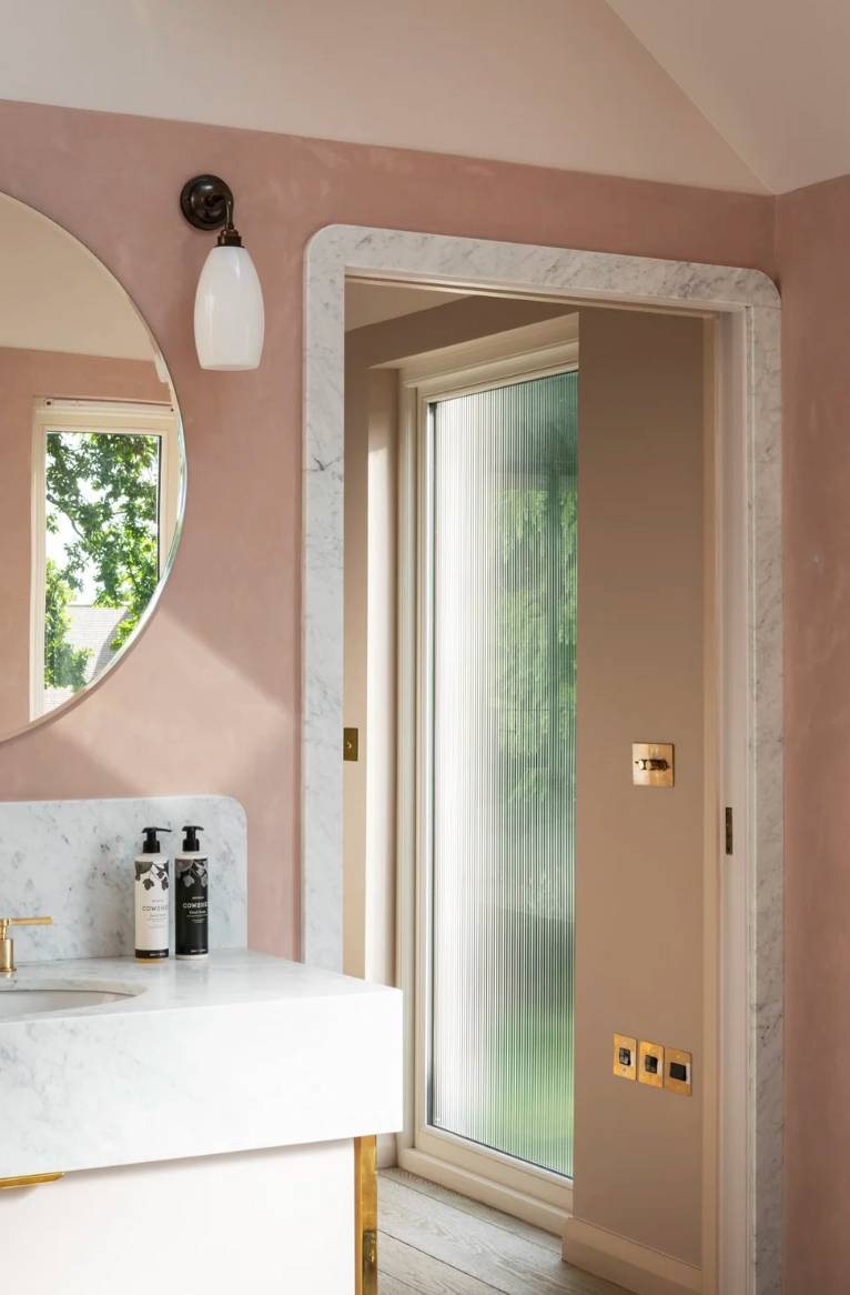 Powder room bathroom location featuring soft pink plaster, a marble vanity basin, and framed mirror, perfect for beauty product campaigns, Love Locations N6.