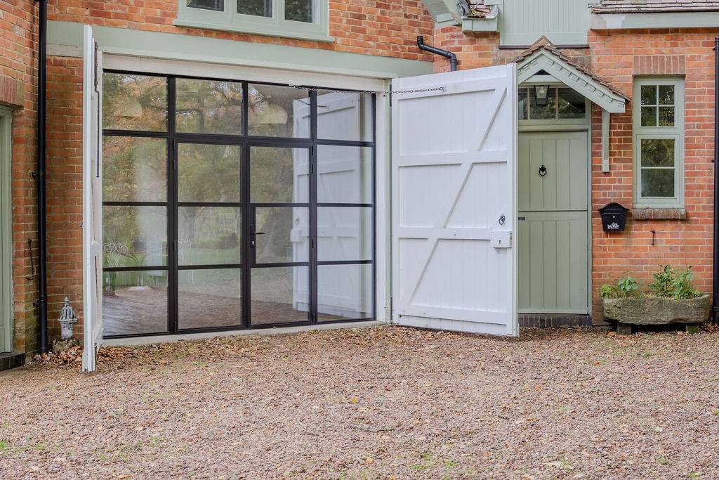 Interior view through steel-framed doors into a spacious reception room at Love Locations property in Liss, Hampshire GU33.