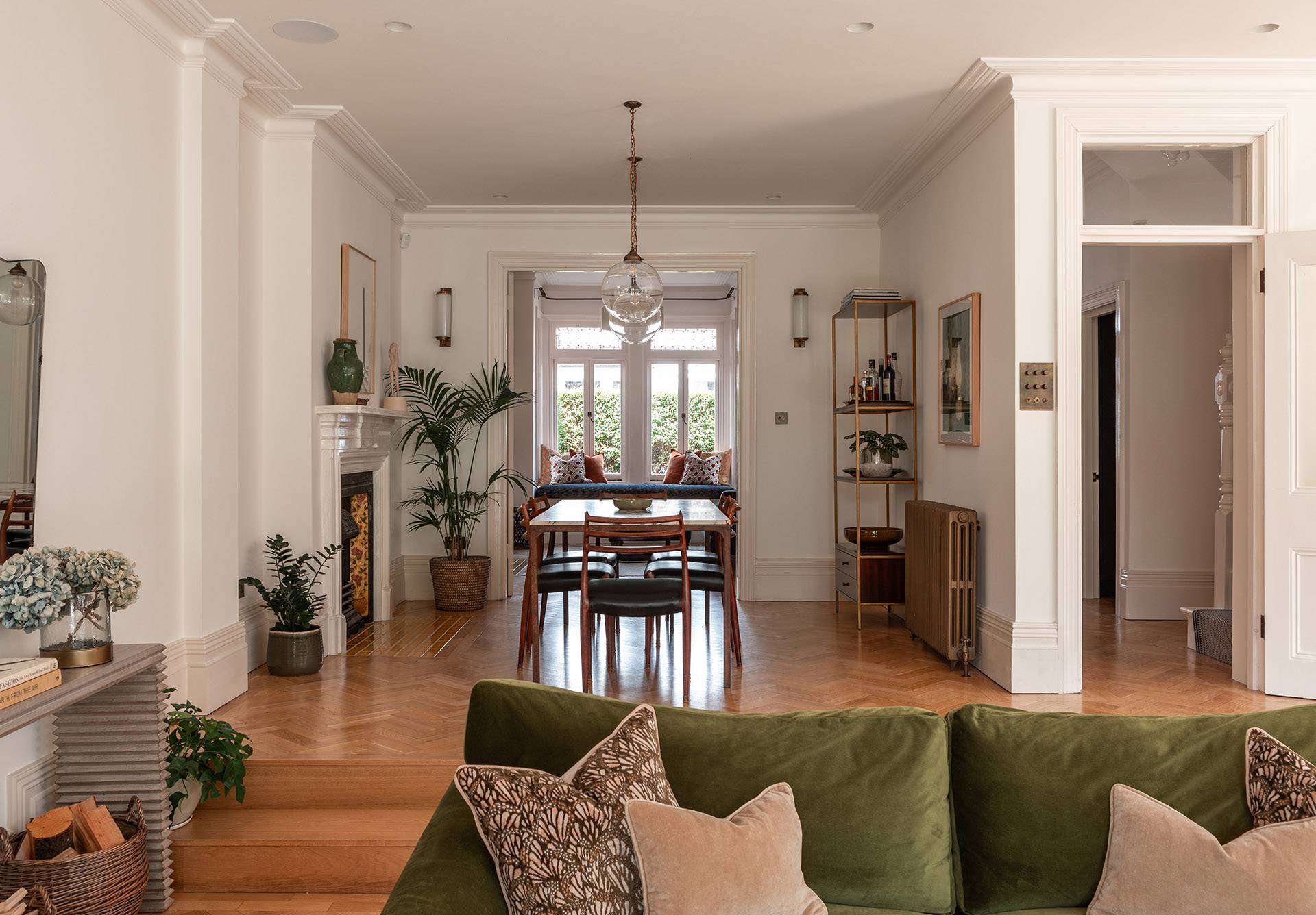Elegant dining room setup featuring a dark wood table, leather chairs, and large bay windows looking out onto greenery, ideal for lifestyle editorial shoots, Love Locations.