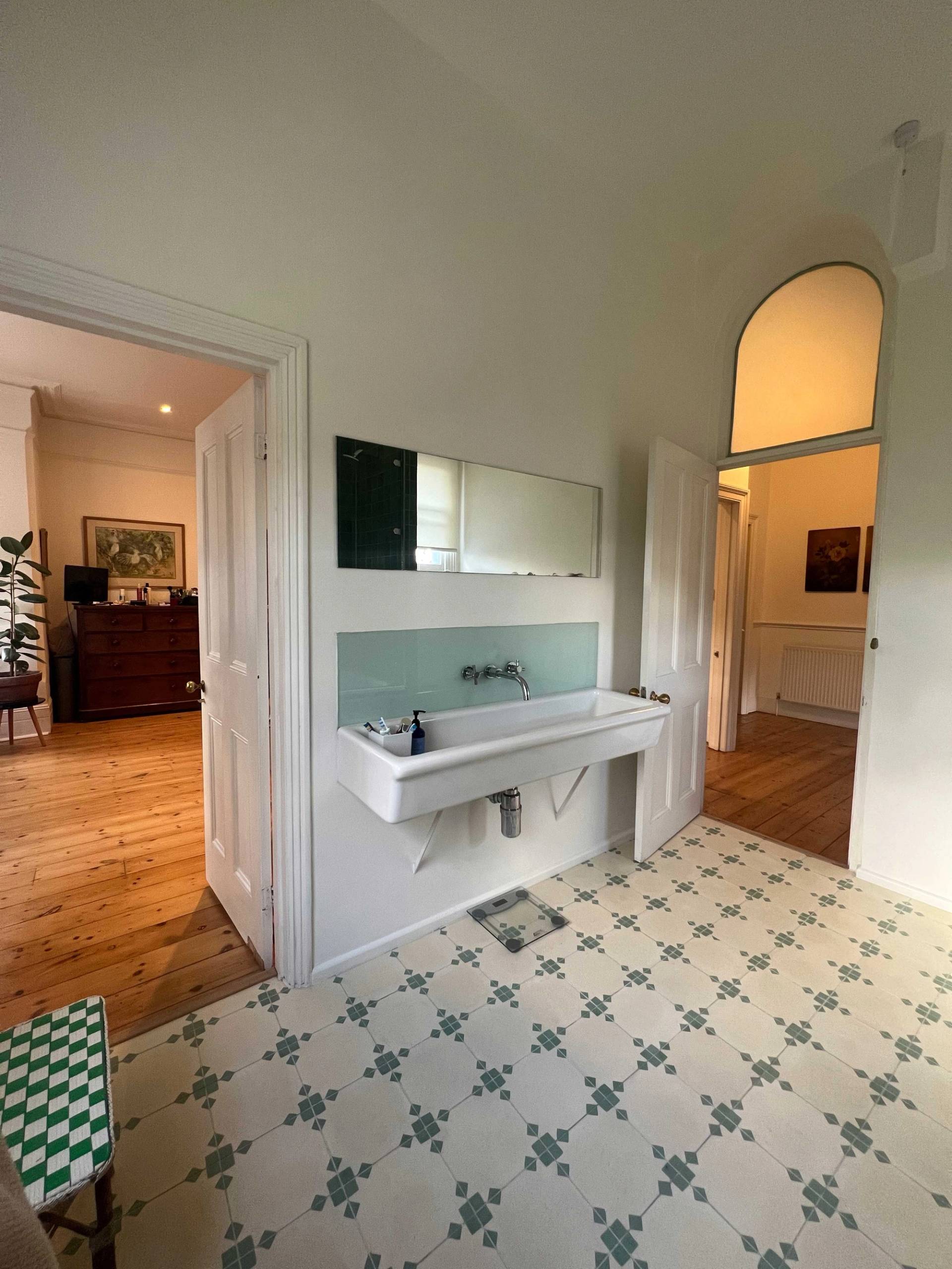 Spacious bathroom featuring a double trough sink unit, pale green wall splashback, and patterned floor tiles, Love Locations SE5.