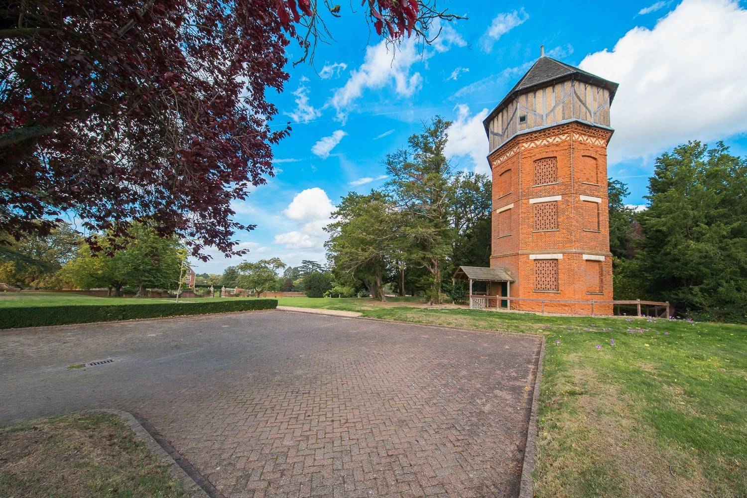 Historic red-brick water tower shoot space set amongst landscaped estate grounds and mature trees via Love Locations.