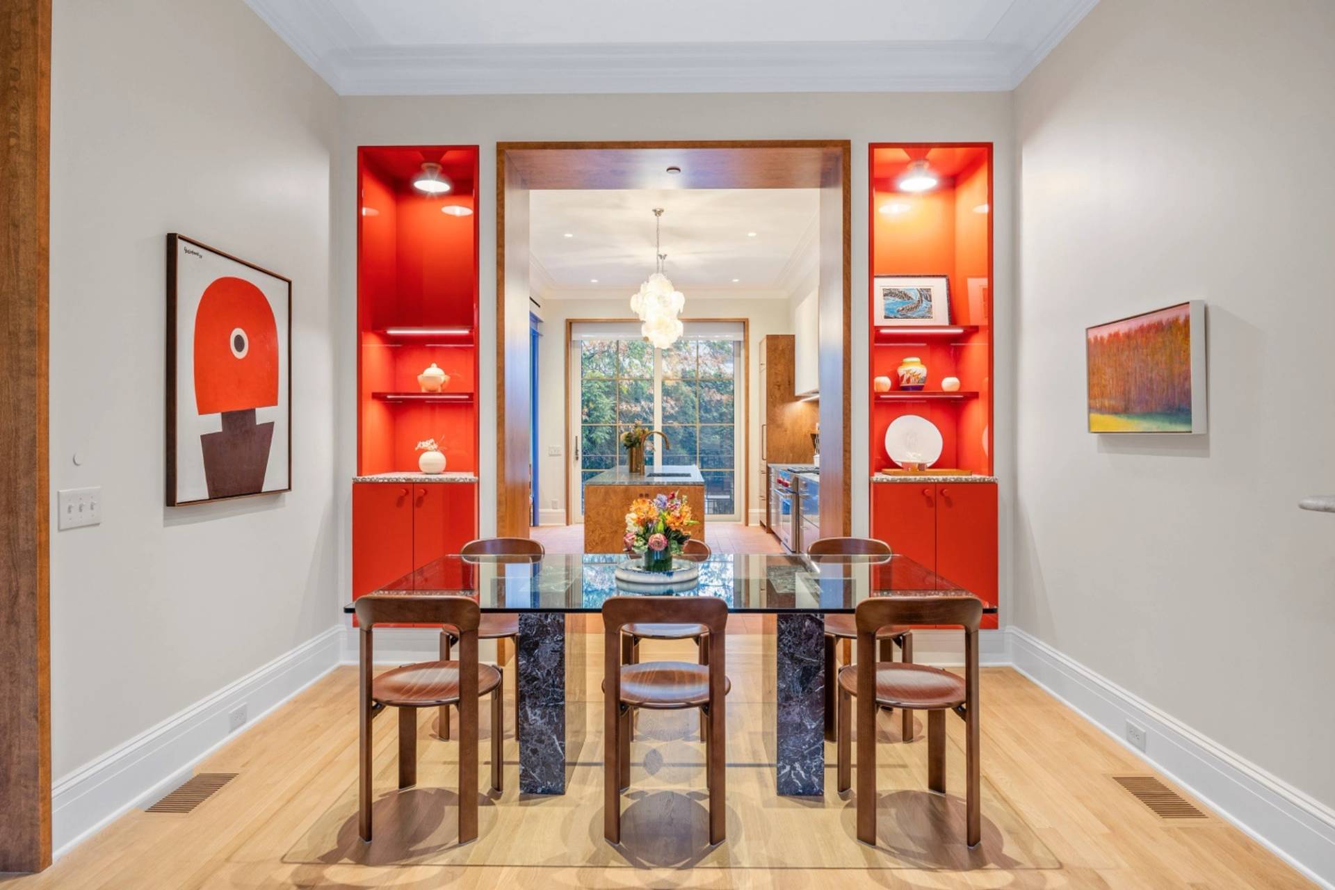 Vibrant dining room film location in a 19th-century Boerum Hill townhouse Brooklyn NY 11217 from Love Locations, featuring orange built-in alcove shelving, double arched doorways, and a modern glass dining table.