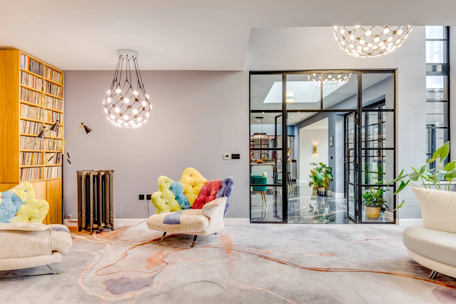 Rainbow striped armchair set beside a internal crittall glass wall in a luxury Cambridge home, Love Locations CB2.