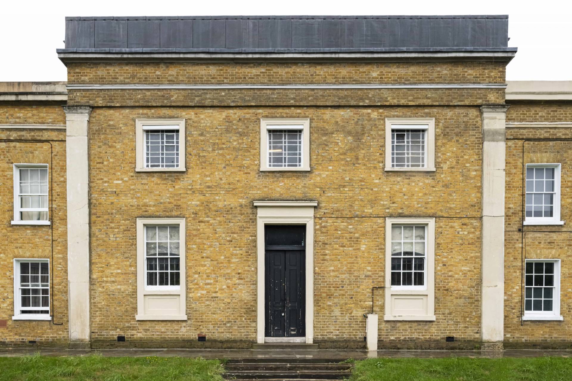 Georgian chapel shoot location hero cover image in Peckham, SE15 featuring yellow stock brick facade, multi-pane sash windows, black entrance door, stone columns, and distressed chapel interiors, the ultimate high-visibility backdrop for feature film productions, music videos, high-fashion editorials, and commercial campaigns via Love Locations.