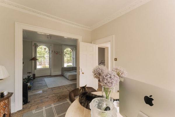 Interior view looking through connecting double doors from a desk workspace into a bright front living room, Love Locations SW9.