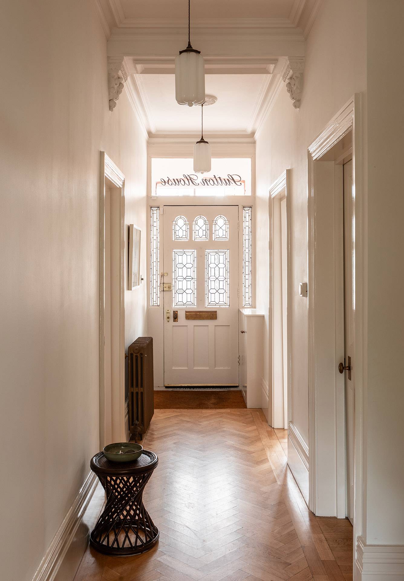 Classic entry hallway showcasing original parquet flooring, decorative glass front door, and neutral plaster walls, ideal for establishing film shots, Love Locations TW1.
