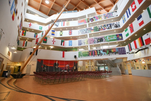 Love Locations large educational campus location BS7: Multi-tiered internal school courtyard and event space draped with colorful flag banners, perfect for crowd scenes, background extras, and commercial filming.