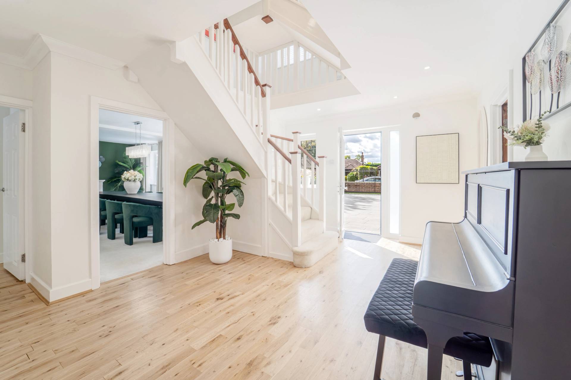 Entrance hallway with white wooden staircase balustrade, crystal chandelier, and front door, Love Locations RM11.