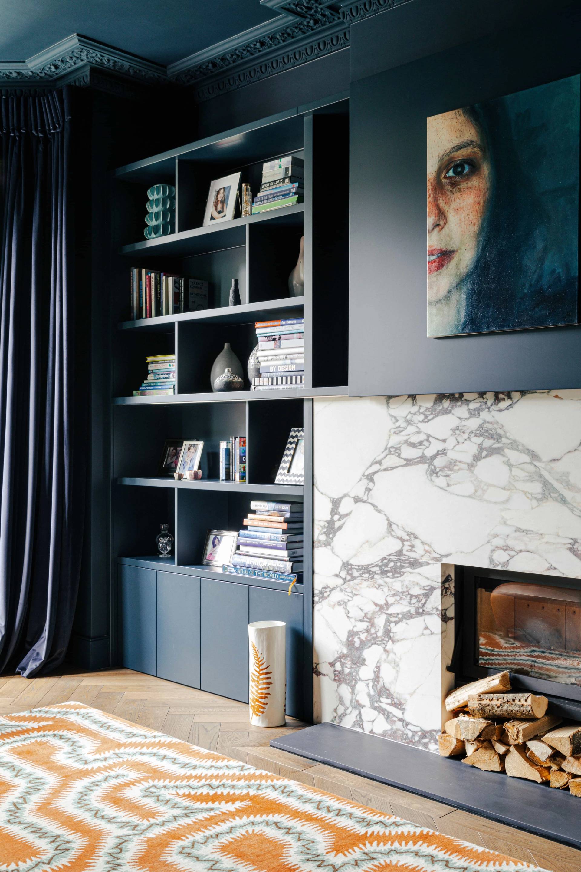 Built-in dark blue bookcase with integrated viola marble fireplace surround, perfect for editorial photography, Love Locations SW13.