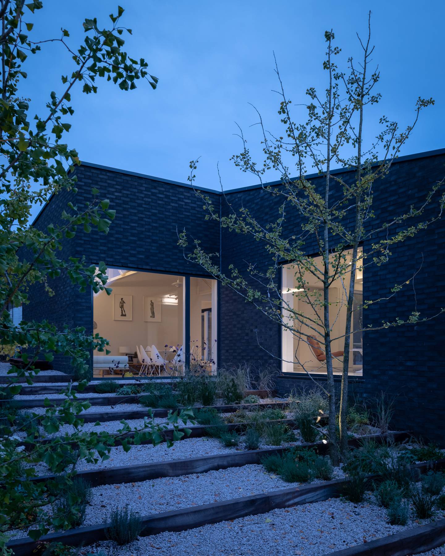 Stepped garden path leading through native planting toward a dark brick modern home facade, Love Locations BN3.