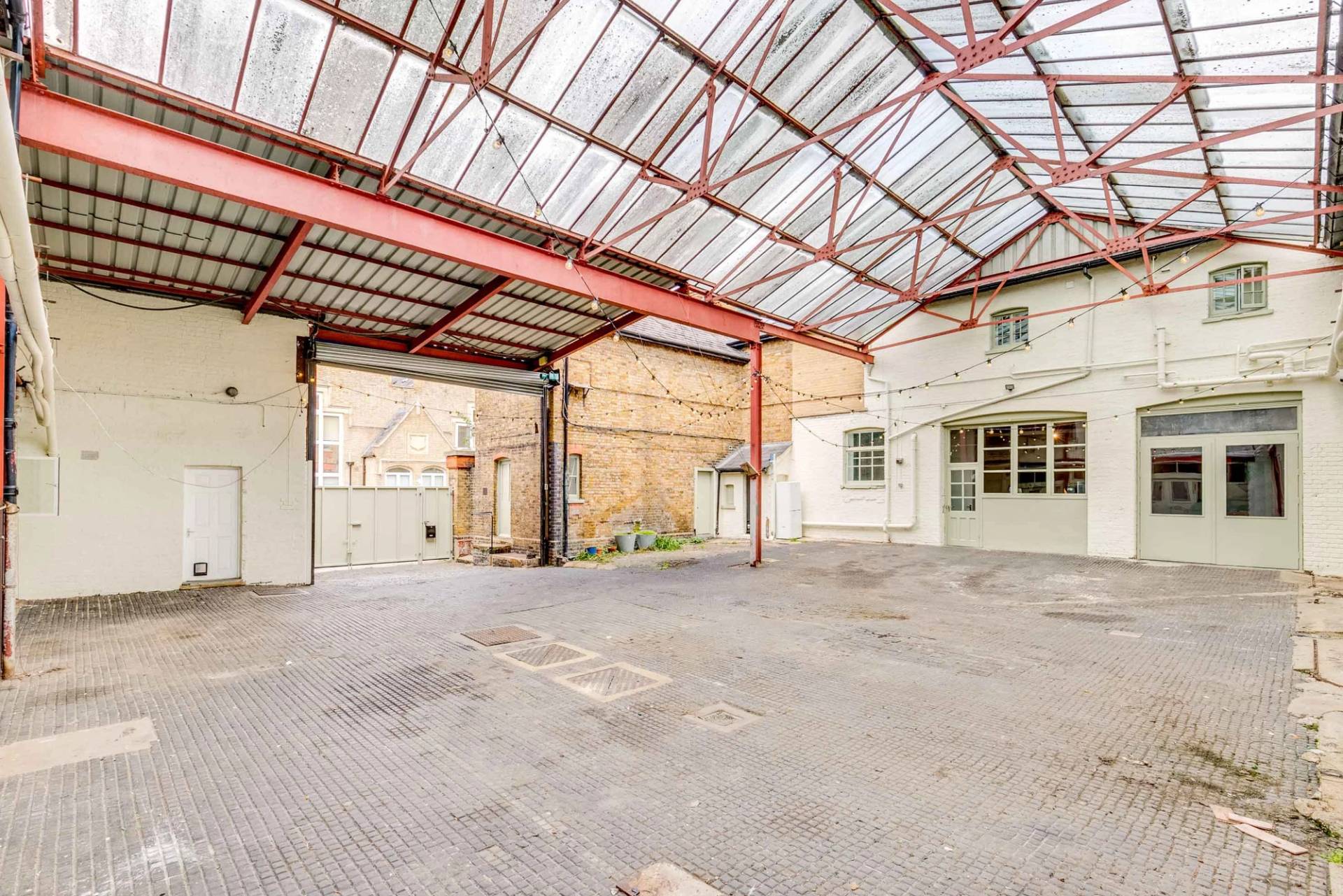 Industrial courtyard location with a textured glass roof and steel beams for commercial filming in Richmond, TW10 via Love Locations.