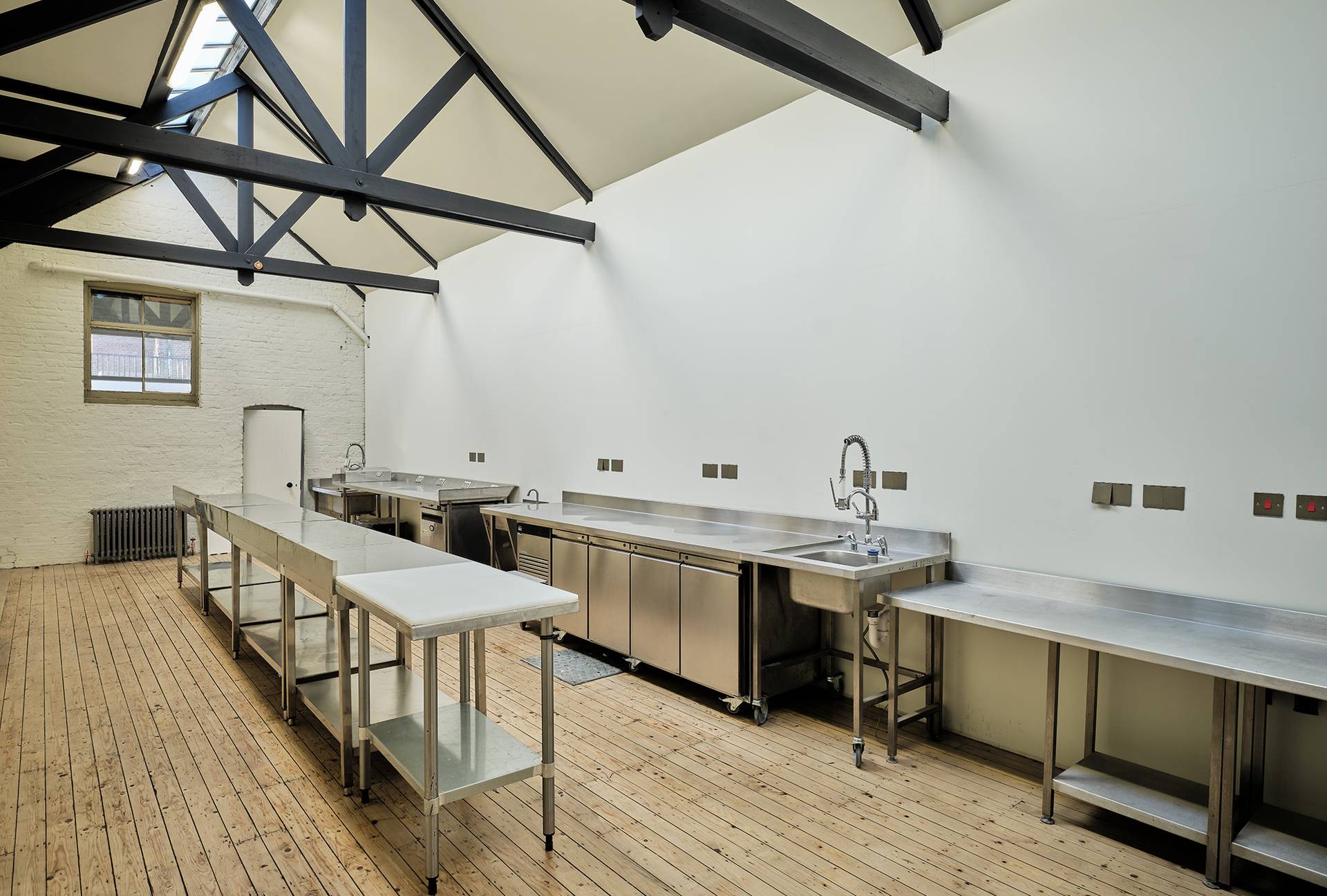 Spacious event prep kitchen equipped with stainless steel sinks, worktops, and commercial appliances, Love Locations.