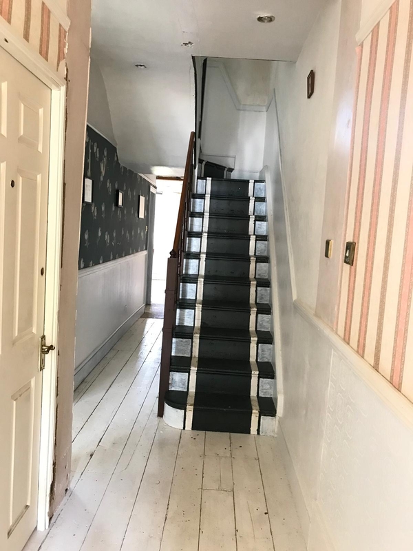 Traditional multi-level staircase landing with painted black steps and a contrasting white wooden balustrade, ideal for atmospheric thriller film sets, Love Locations SE25.