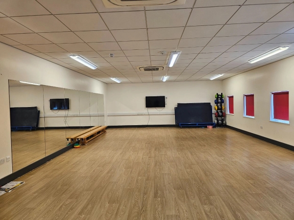 Professional school dance studio location space with full-length mirrored walls, ballet barres, and wood-effect flooring, Love Locations.