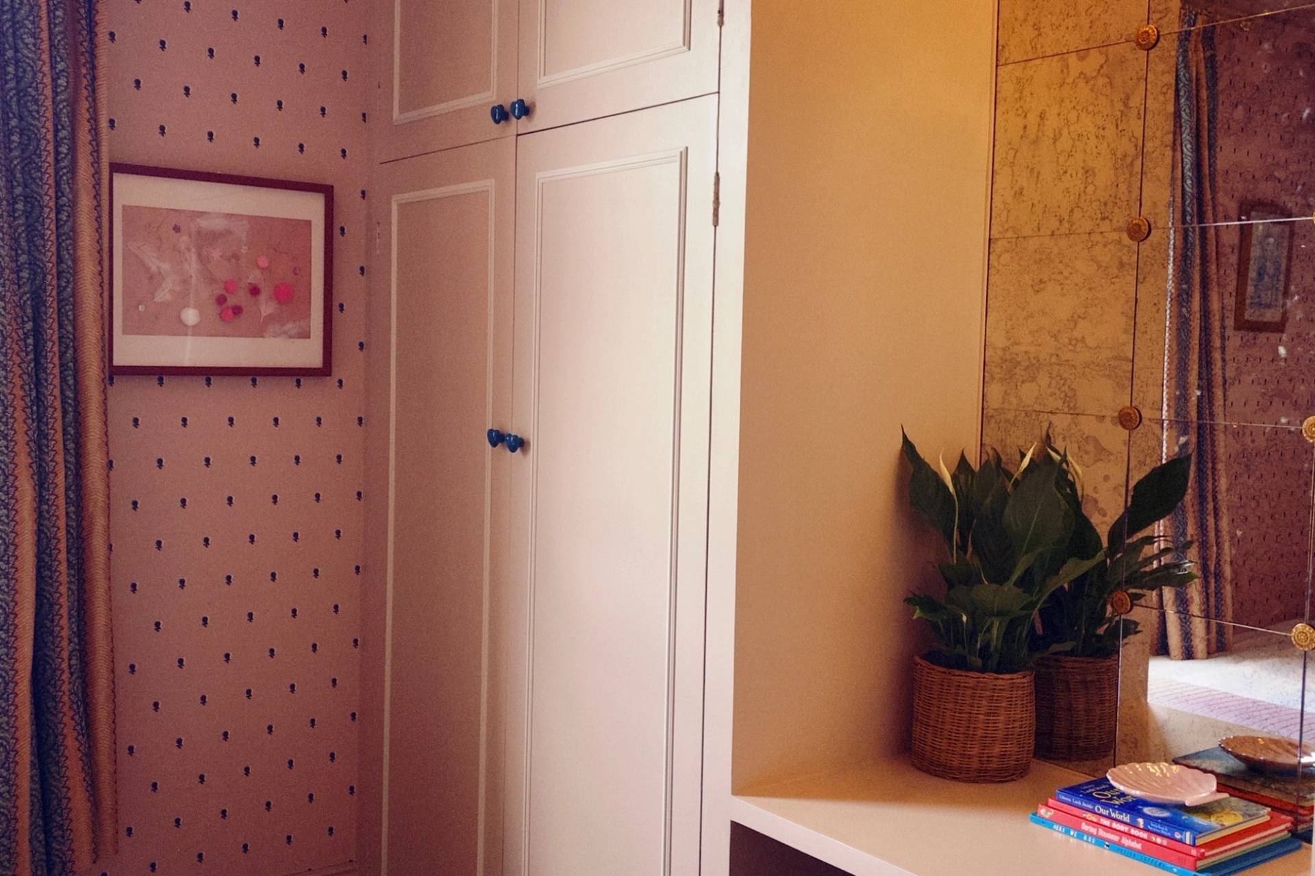 Custom built-in white wardrobe cabinetry next to a bright indoor houseplant corner, perfect for home organization brand shoots, Love Locations.