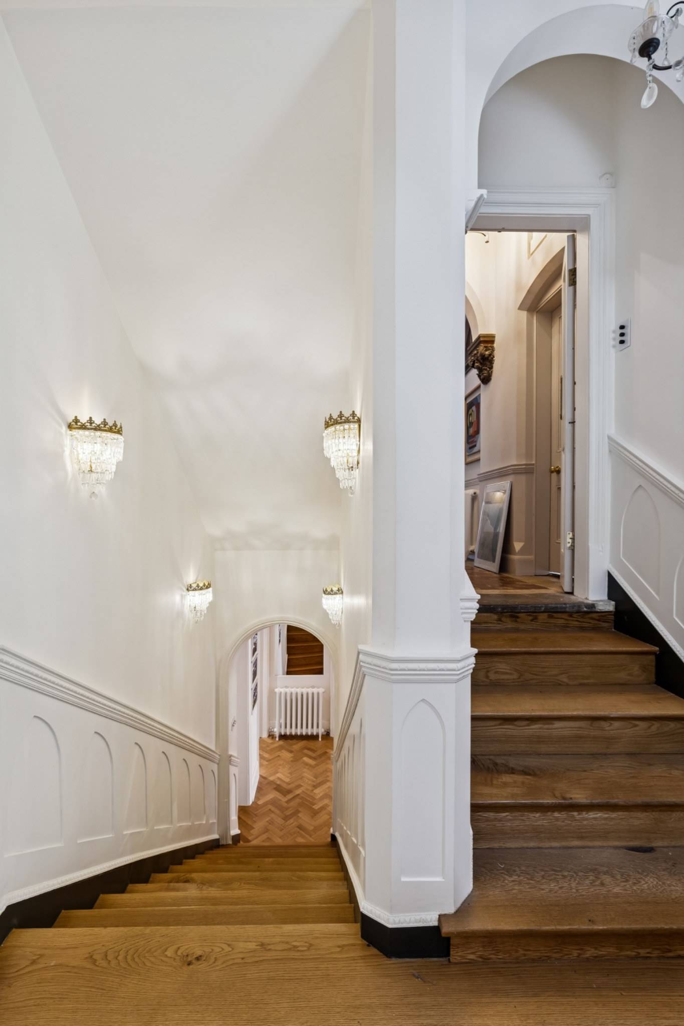 Elegant white staircase and landing area in a gothic style home in Hampstead NW3 from Love Locations.