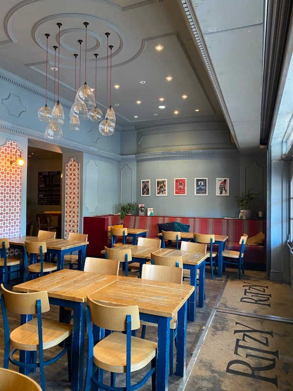 Open-plan dining and event layout featuring multiple wooden table setups and modern pendant lights inside The Ritzy Cafe shoot venue in Brixton SW2 from Love Locations.