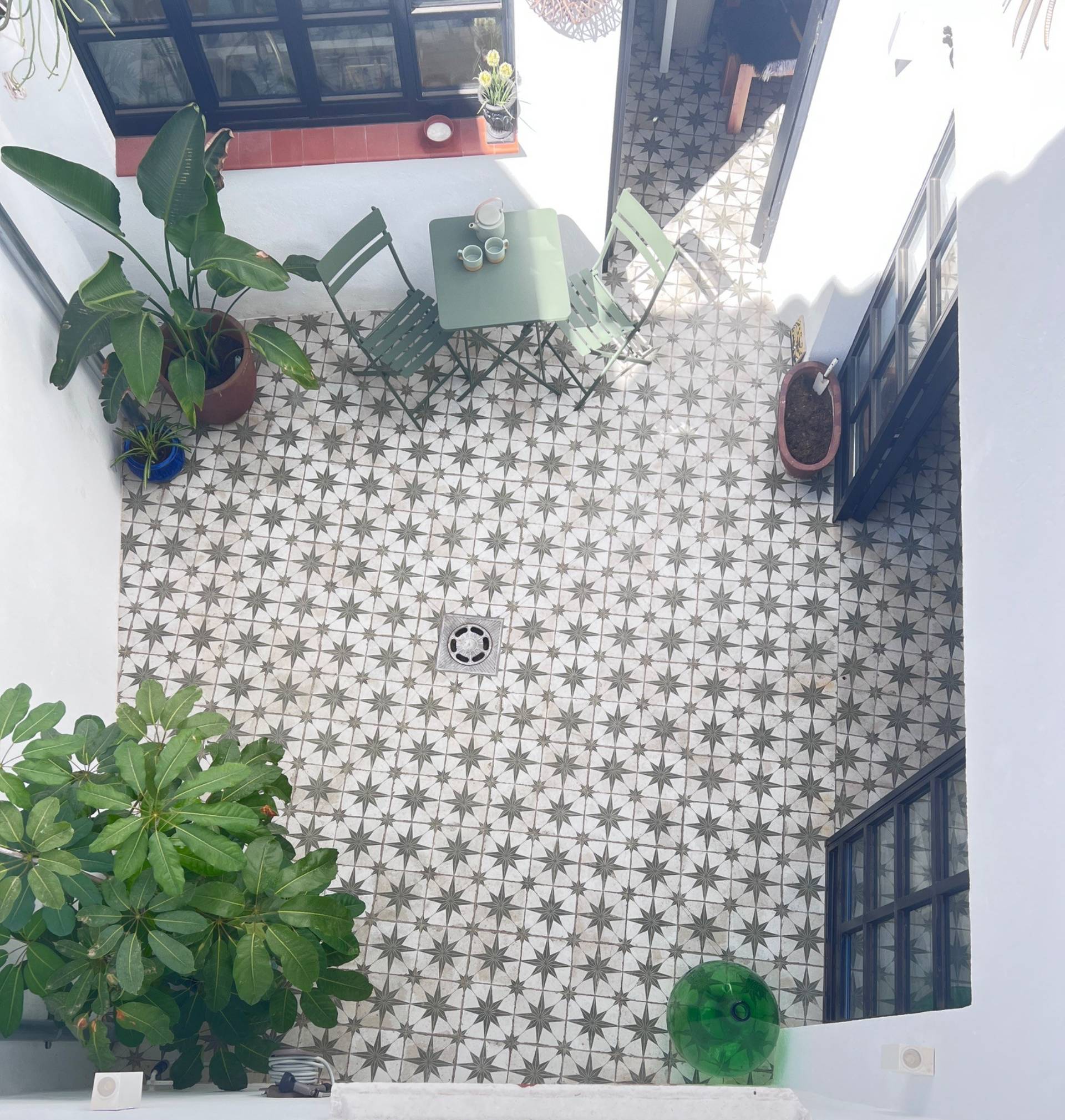 Top-down view of an enclosed Andalucian internal patio in Jimena de la Frontera Cádiz available via Love Locations, with vibrant green plants and decorative floor tiles.