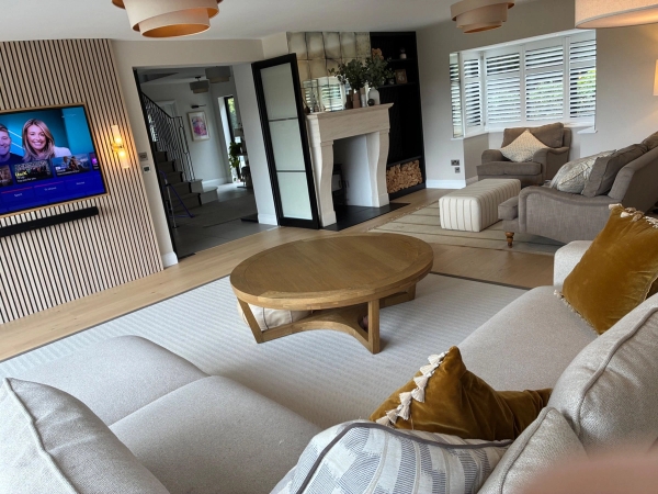Editorial lounge area for brand photography in Essex CM4 by Love Locations, featuring plush cream seating, a low wooden coffee table, and open transitions between living spaces.