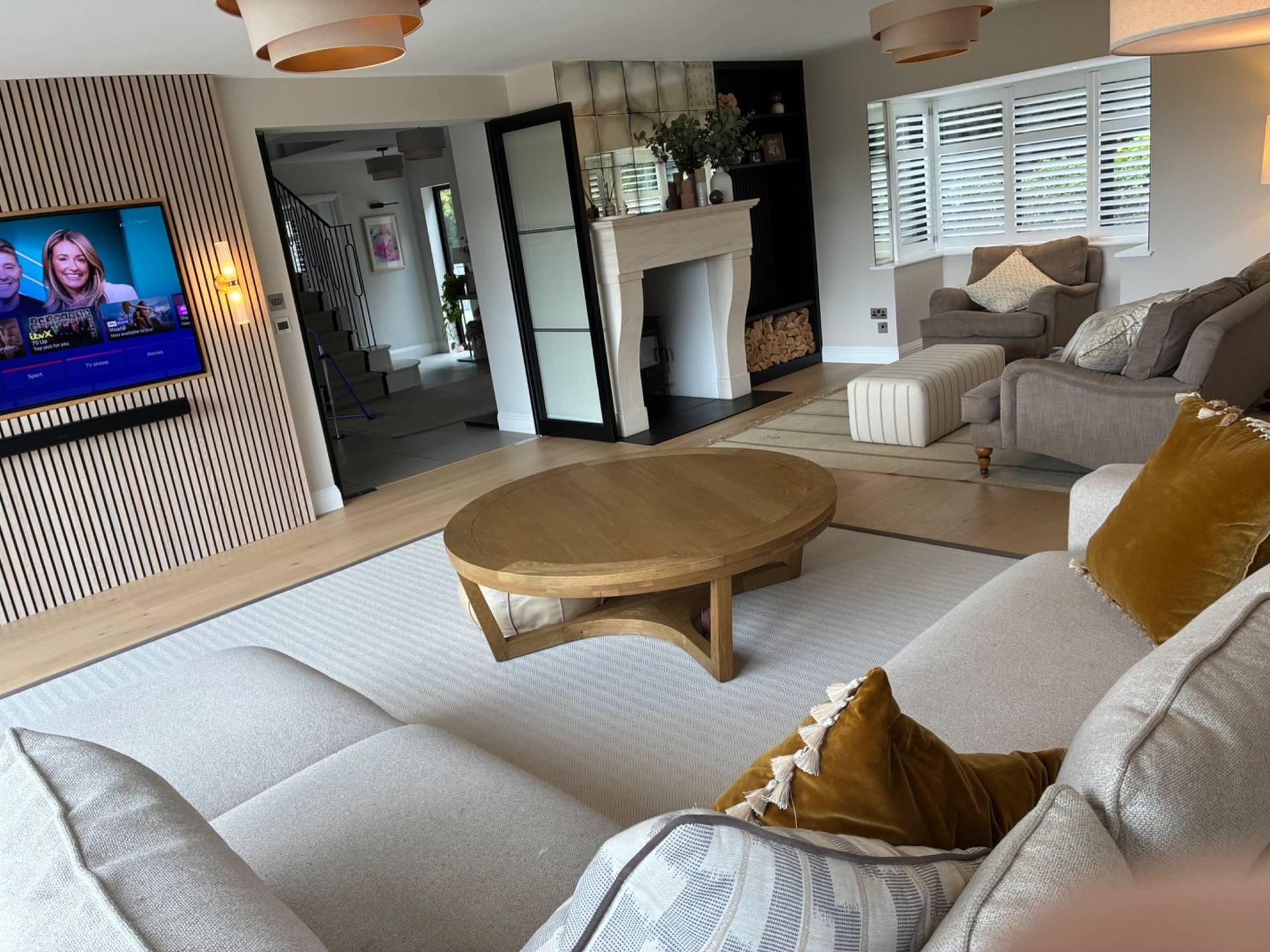 Editorial lounge area for brand photography in Essex CM4 by Love Locations, featuring plush cream seating, a low wooden coffee table, and open transitions between living spaces.