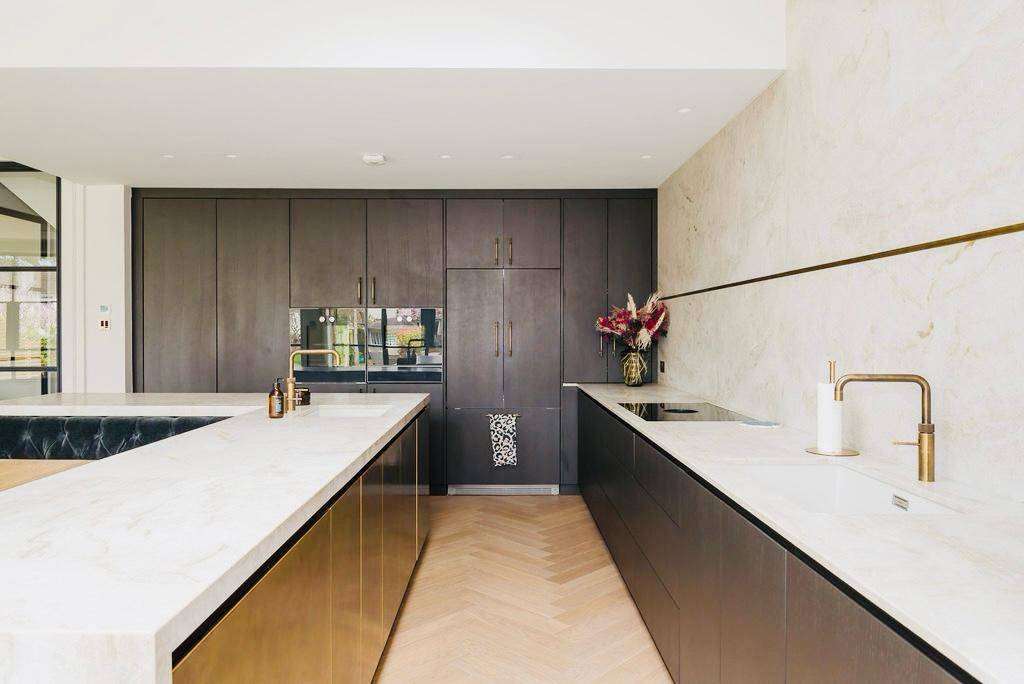 Sleek kitchen prep area with white marble countertops and dark timber cabinetry, Love Locations TW11.
