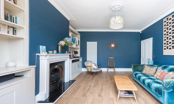 Classic cast iron fireplace insert inside an Edwardian terraced house location with deep blue walls, listed by Love Locations.