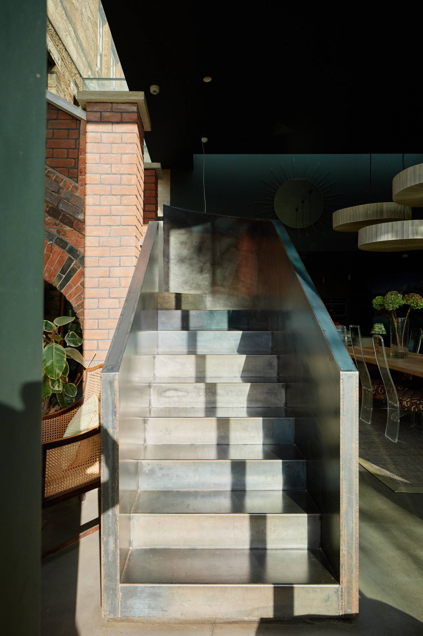 Modern industrial metal staircase with glass balustrades set set against exposed brick walling, ideal for fashion campaigns, Love Locations SW20.