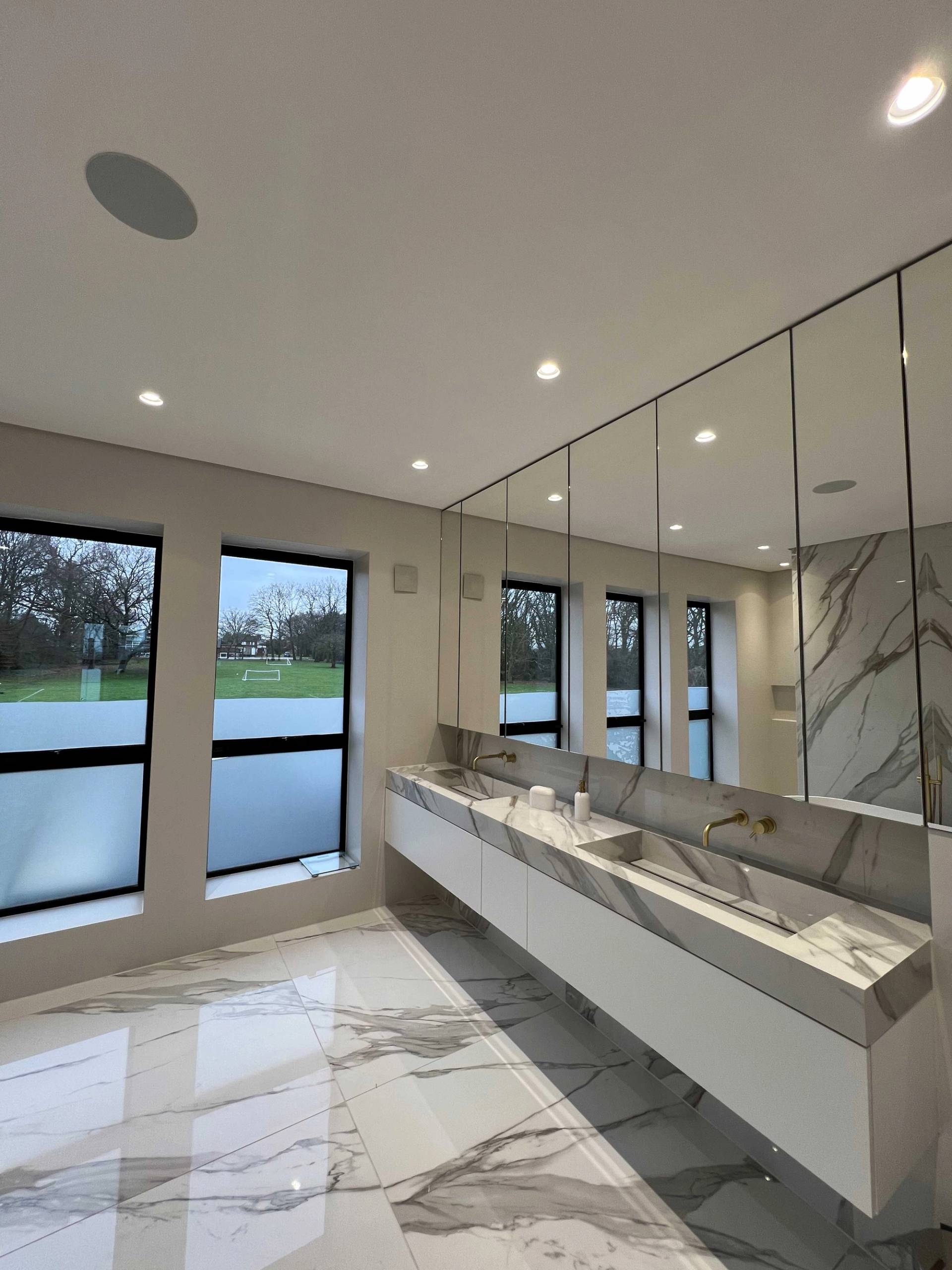 Spacious master bathroom with double marble vanity sinks, full-width mirror, and black window frames, perfect for luxury grooming campaigns, Love Locations N3.