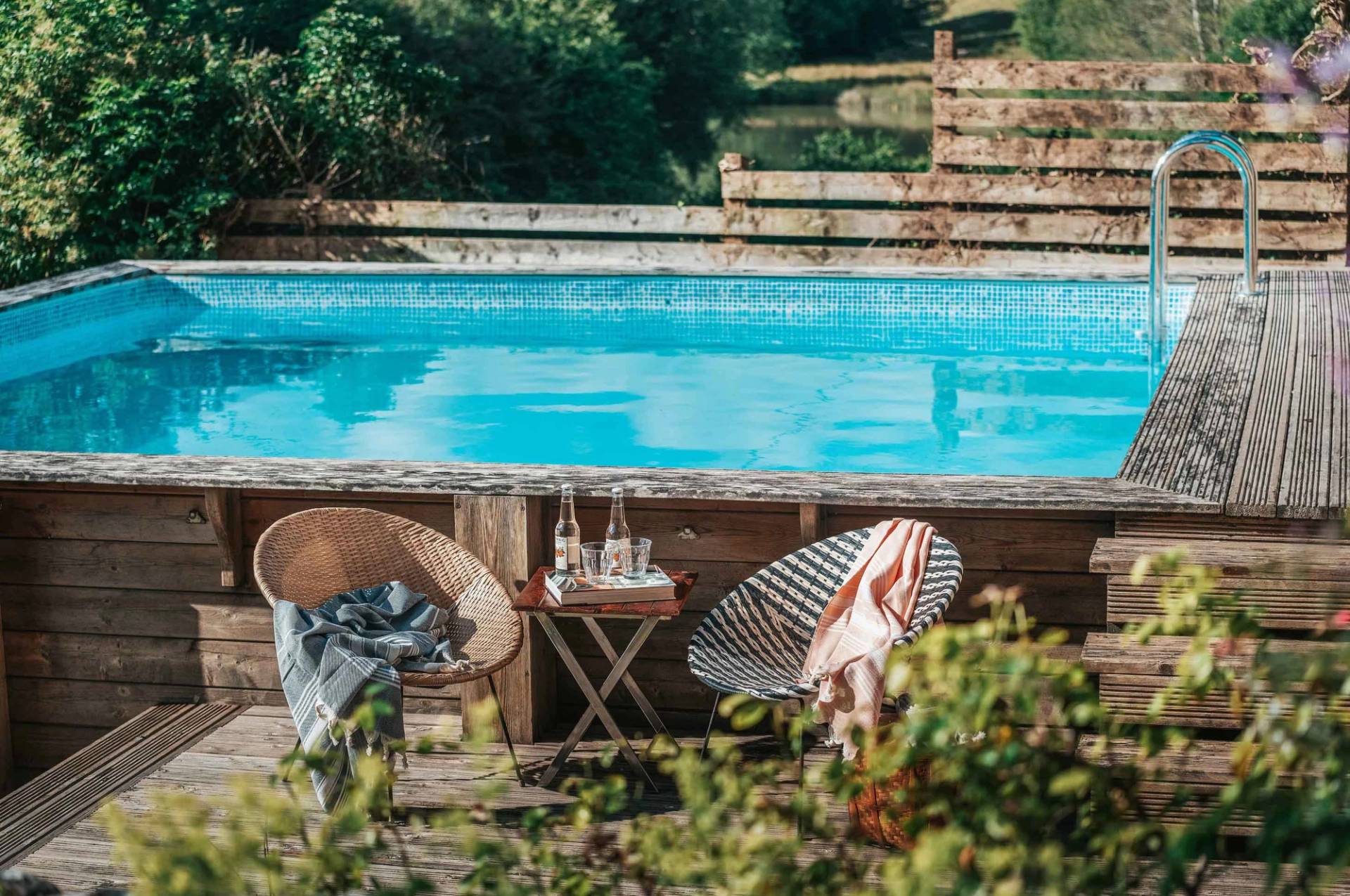 Poolside terrace seating area with wire chairs and a clear blue swimming pool for lifestyle brand shoots by Love Locations.