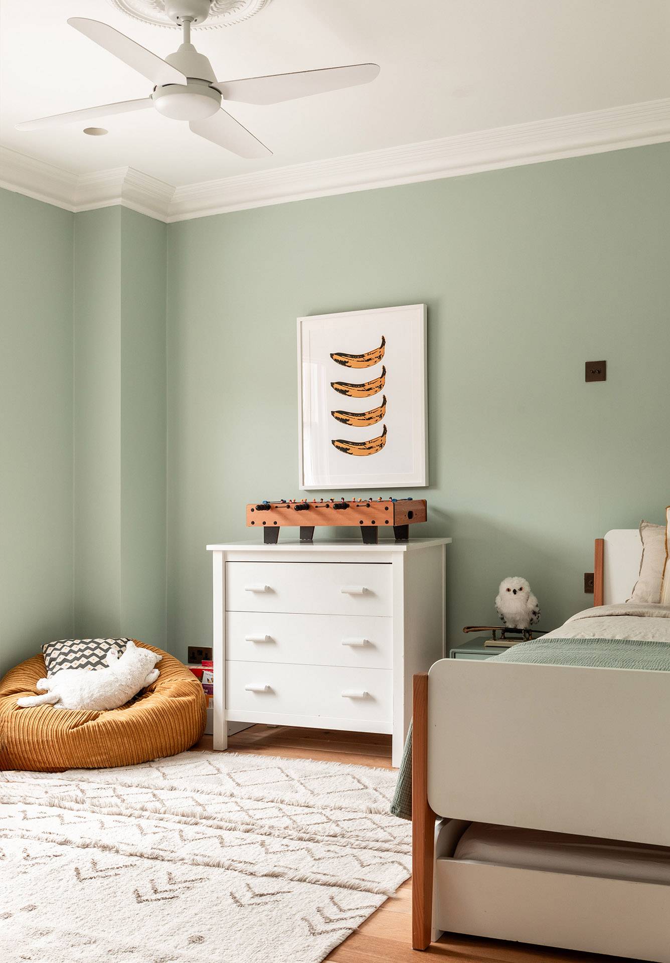 Minimalist kids room corner with a white dresser, soft rug, and neutral wall art, Love Locations TW1.