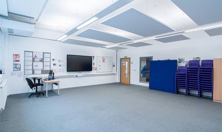 Empty modern classroom or drama room filming space in Hove BN3 featuring carpeted floors, wall monitor, and high ceilings through Love Locations.