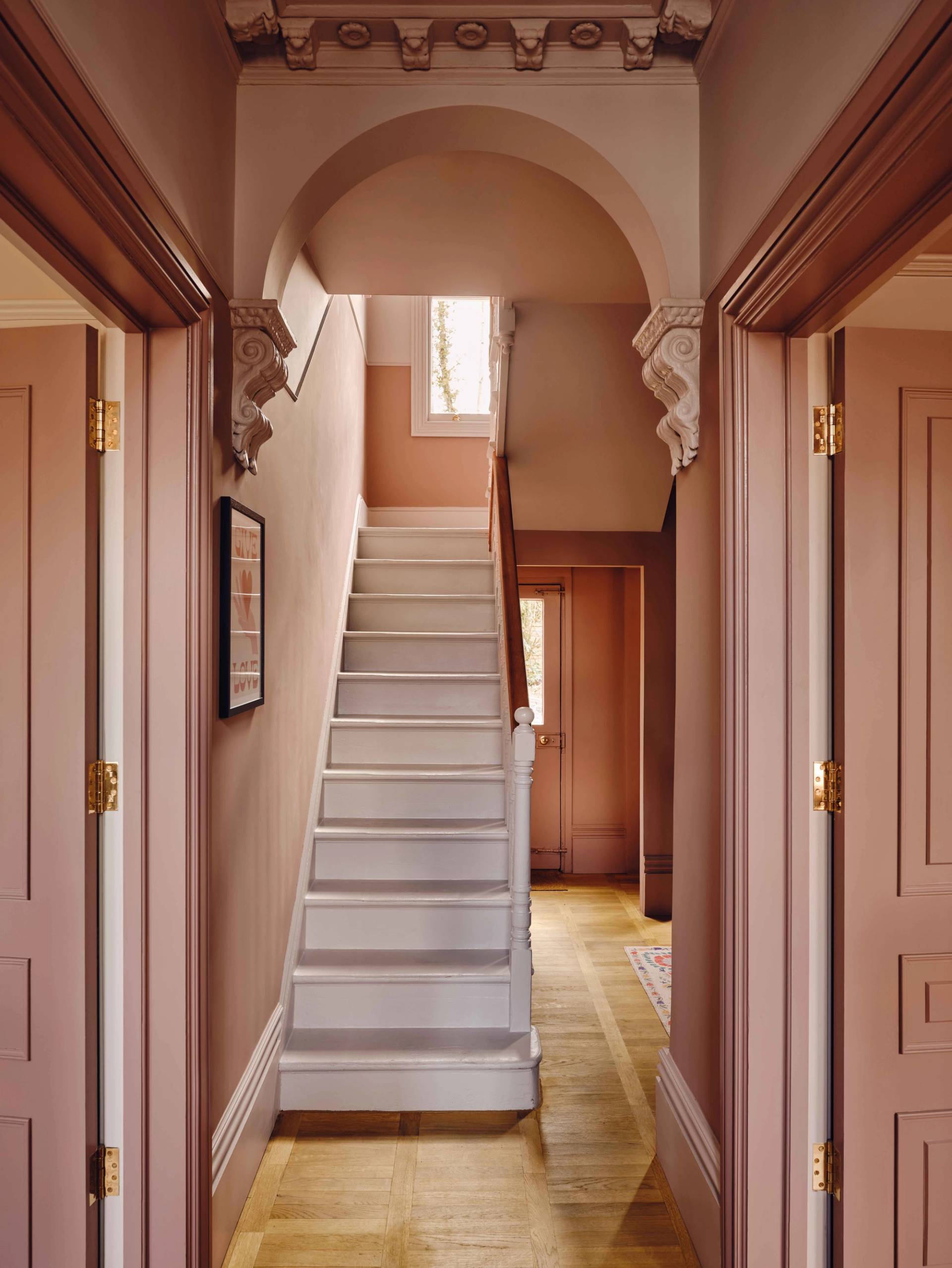 Staircase view showcasing plaster pink walls, white turned spindles, and period architraves, Love Locations CR0.