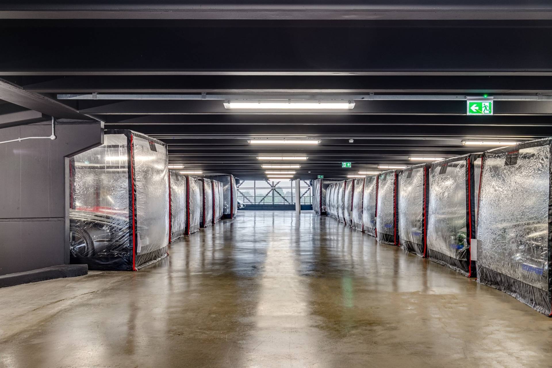Wide industrial hall with clear car storage capsules in a Brentford 1950s factory shoot space from Love Locations.