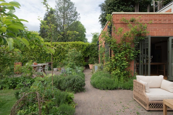 Stylish outdoor garden of a modern Surrey house in Horsley, showcasing natural light and greenery, Love Locations.