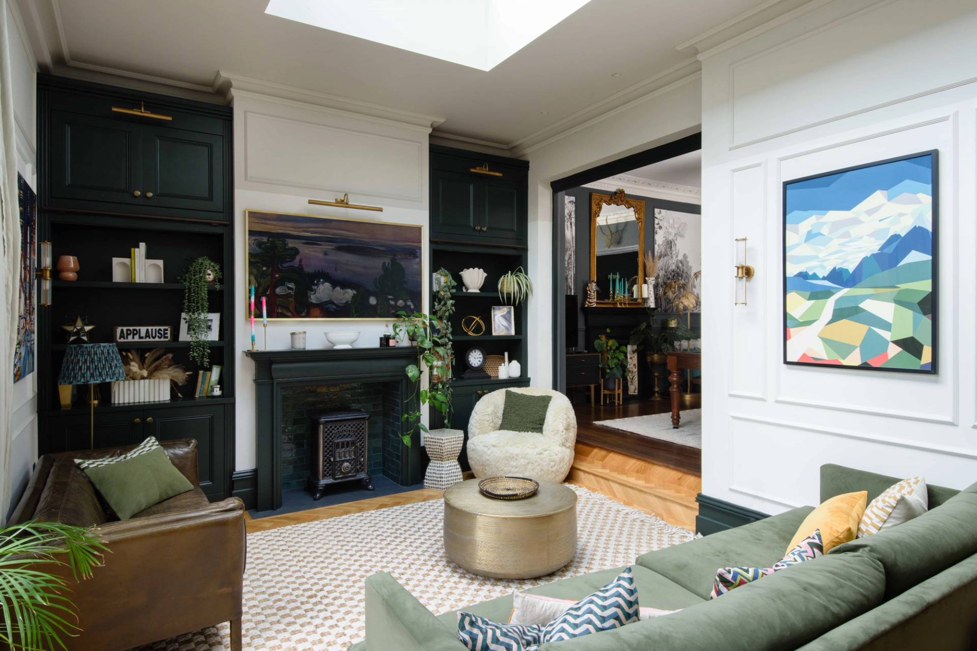 Spacious open-plan living and dining space in TW11 featuring an inset fireplace, swivel armchair, and skylight windows, Love Locations Teddington.