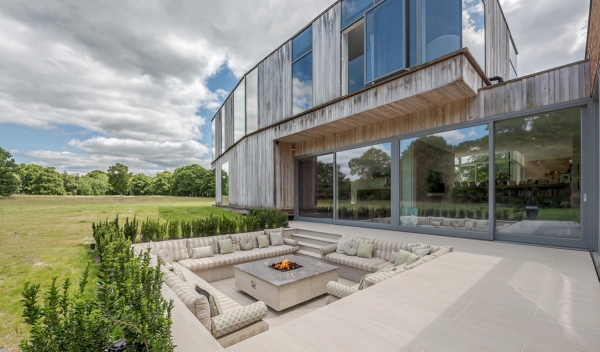 Love Locations modern courtyard location Godalming Surrey GU8: High-concept architectural sunken stone seating area with a central square fire pit, a highly cinematic setting for TV and film.